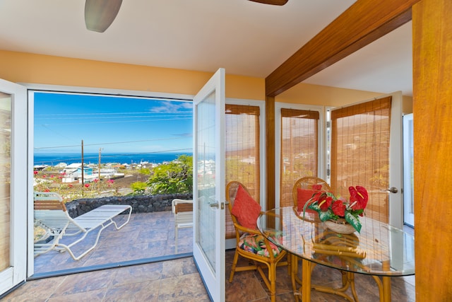 sunroom / solarium with beam ceiling and a water view