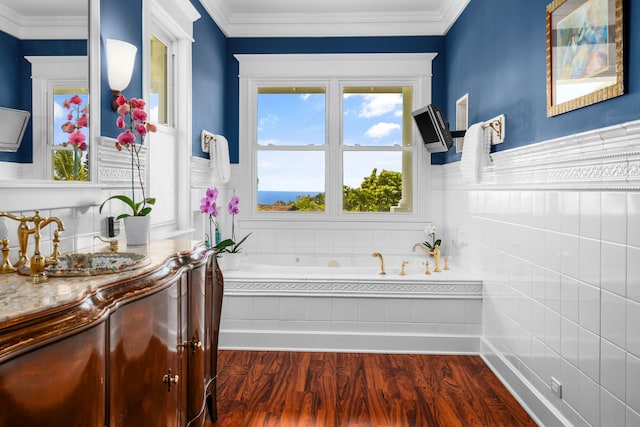 bathroom with vanity, a relaxing tiled tub, hardwood / wood-style floors, and ornamental molding