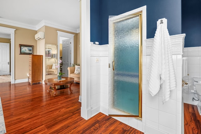 bathroom with crown molding, a wall unit AC, hardwood / wood-style flooring, and walk in shower