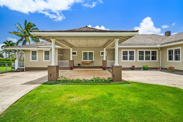 rear view of house featuring a lawn