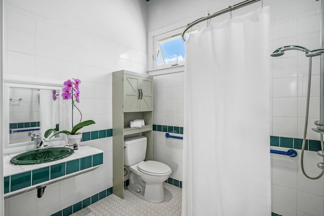 bathroom featuring tile walls, sink, a shower with curtain, and toilet