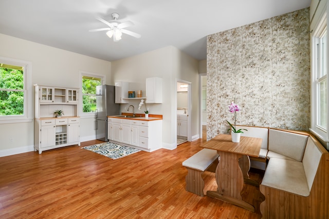 dining space featuring sink, light hardwood / wood-style floors, and ceiling fan