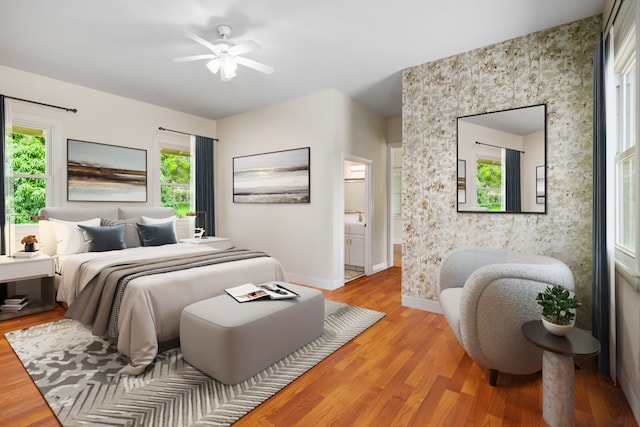 bedroom featuring connected bathroom, hardwood / wood-style flooring, and ceiling fan