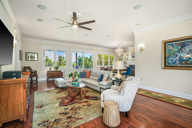 living room with ceiling fan with notable chandelier, ornamental molding, a wealth of natural light, and dark hardwood / wood-style floors