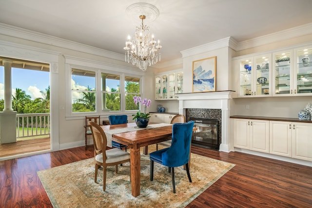 dining space featuring ornamental molding, a chandelier, dark hardwood / wood-style floors, and a premium fireplace