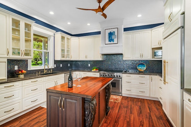 kitchen featuring sink, a kitchen island, high quality appliances, wood counters, and ornamental molding