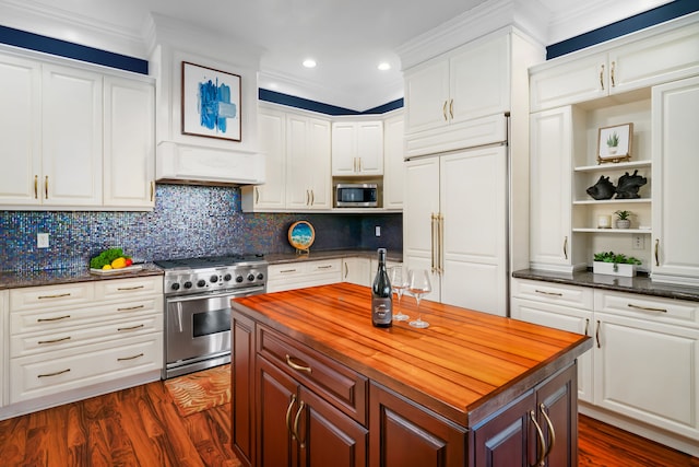 kitchen with built in appliances, crown molding, white cabinetry, and dark hardwood / wood-style flooring