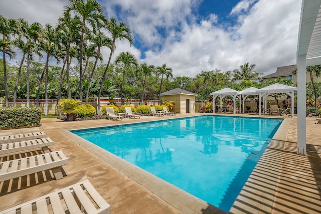 view of swimming pool with a gazebo, an outbuilding, and a patio