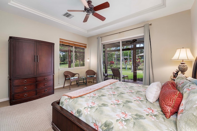 carpeted bedroom featuring ceiling fan, a tray ceiling, and access to exterior