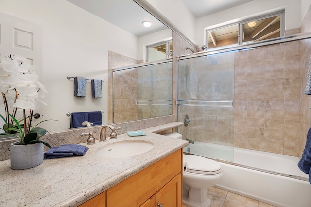 full bathroom with vanity, combined bath / shower with glass door, toilet, and tile patterned floors