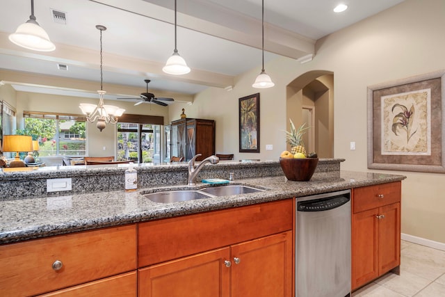 kitchen with light stone countertops, stainless steel dishwasher, ceiling fan with notable chandelier, pendant lighting, and sink