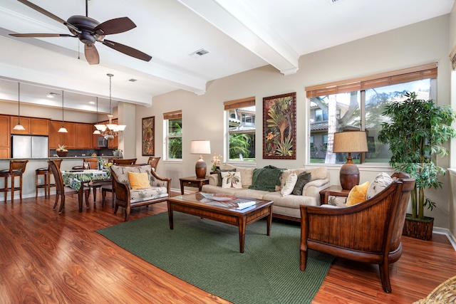 living room with beam ceiling, wood-type flooring, and ceiling fan with notable chandelier