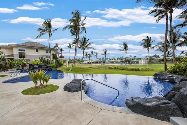 view of pool with a water view and a yard