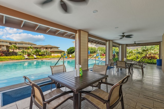 exterior space with outdoor dining space, an outdoor pool, and ceiling fan