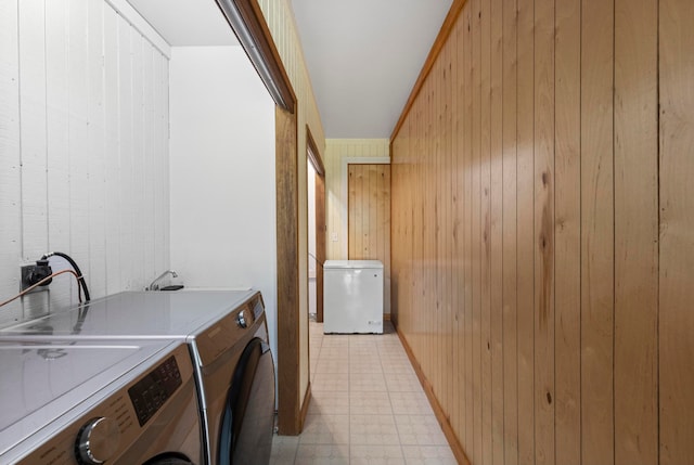 washroom with sink, washer and clothes dryer, and wood walls