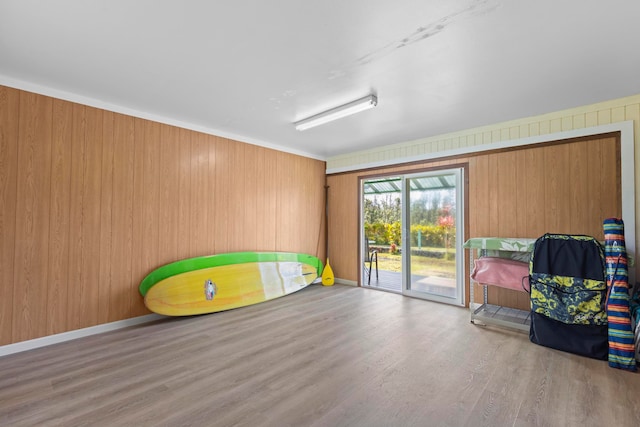 interior space with light hardwood / wood-style flooring and wood walls