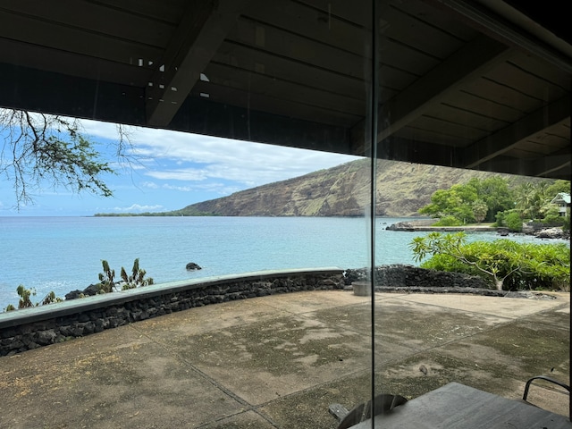 view of patio featuring a water and mountain view