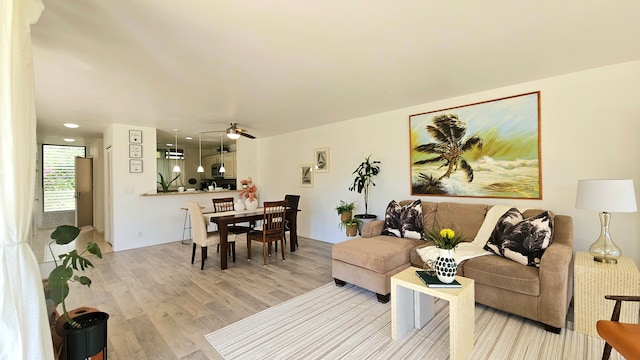 living room with ceiling fan and light wood-type flooring