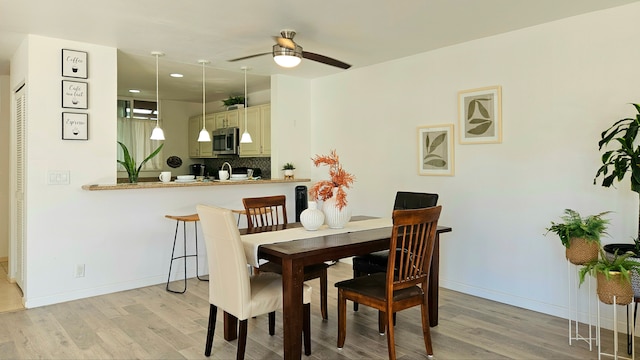 dining area featuring light hardwood / wood-style flooring and ceiling fan