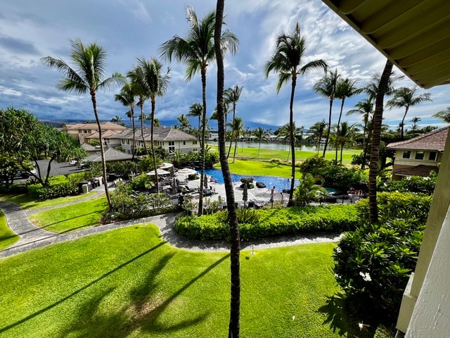 view of property's community with a lawn and a water view