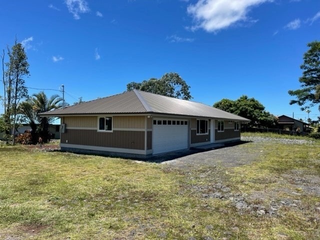 view of side of property featuring a garage and a lawn