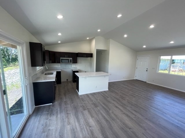 kitchen with a center island, sink, lofted ceiling, and dark wood-type flooring