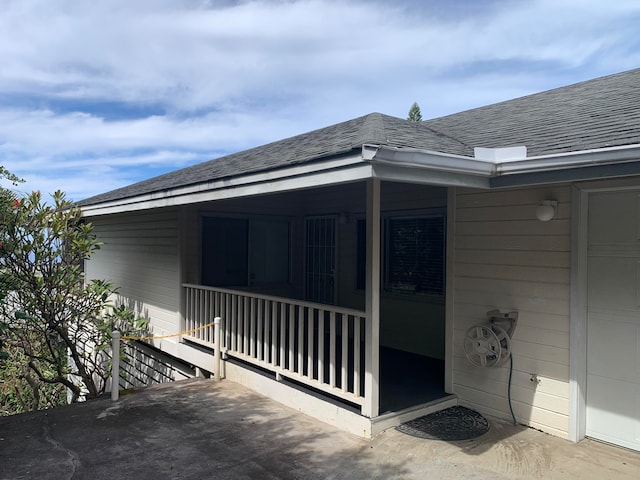 view of exterior entry with a porch and a garage