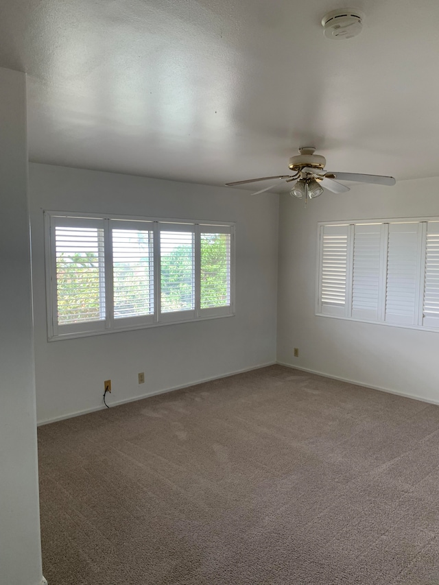 spare room featuring ceiling fan and carpet flooring