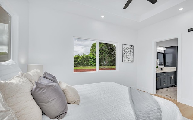 bedroom with ensuite bath, ceiling fan, and light wood-type flooring