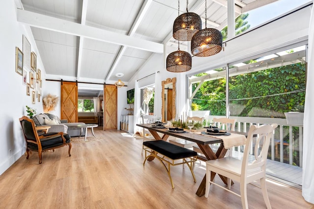 sunroom / solarium with lofted ceiling with beams, a barn door, and a healthy amount of sunlight