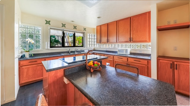 kitchen featuring sink, black electric stovetop, and a kitchen island