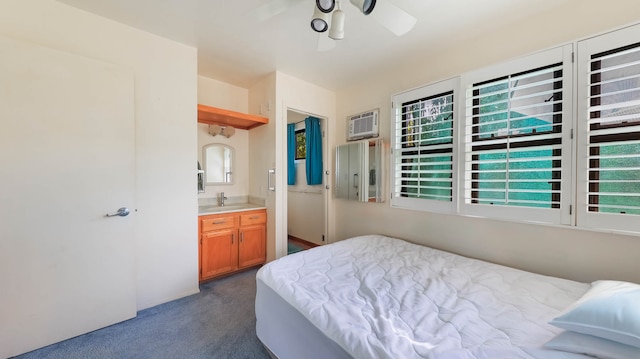 bedroom with ensuite bath, sink, dark colored carpet, ceiling fan, and a wall mounted AC