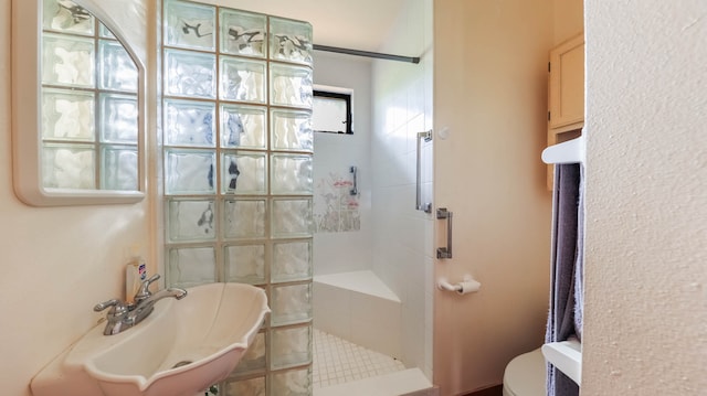 bathroom with toilet and a tile shower