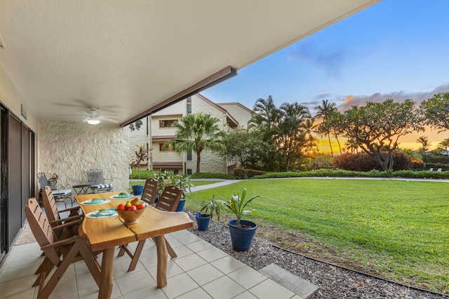 patio terrace at dusk with a lawn and ceiling fan