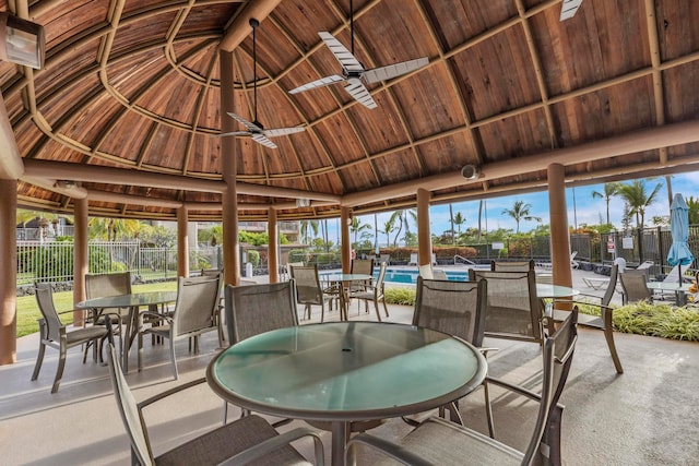 sunroom featuring vaulted ceiling with beams, ceiling fan, and wood ceiling