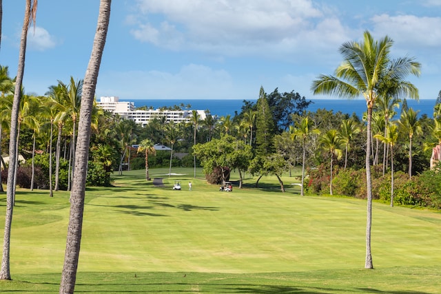 surrounding community with a water view and a lawn