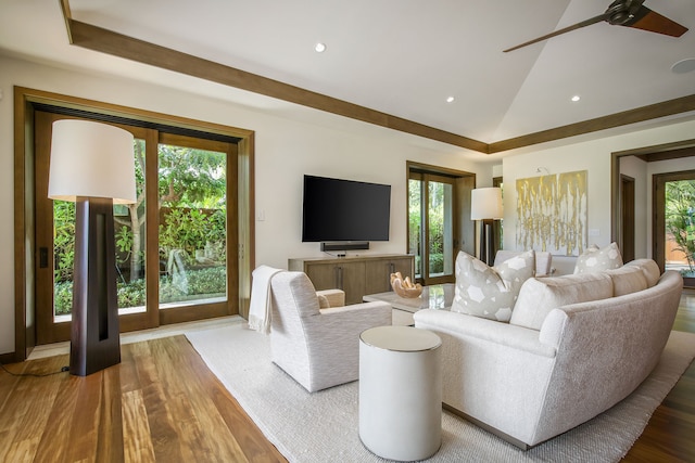 living room with ceiling fan, wood-type flooring, and vaulted ceiling