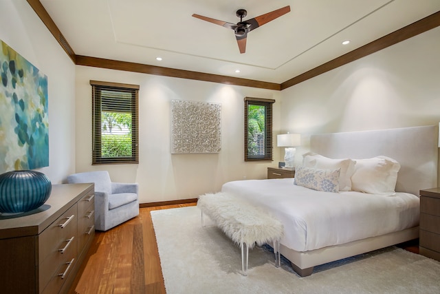 bedroom with ornamental molding, wood-type flooring, and ceiling fan