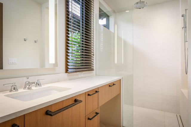 bathroom with vanity and a tile shower