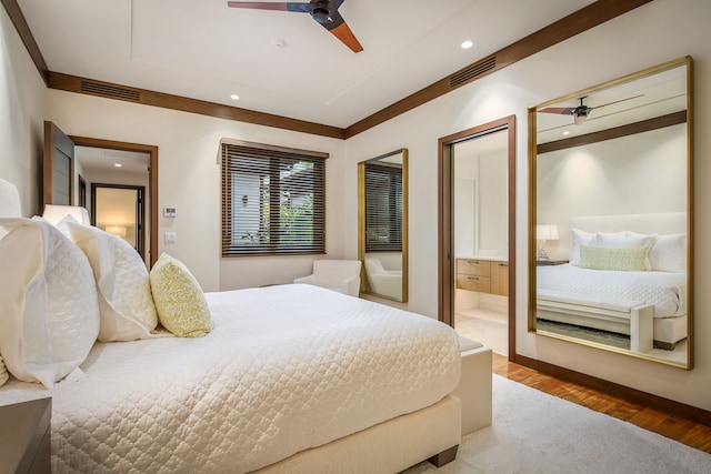 bedroom with ornamental molding, ceiling fan, wood-type flooring, and ensuite bath