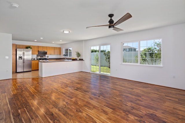 unfurnished living room featuring ceiling fan, light wood-type flooring, and sink