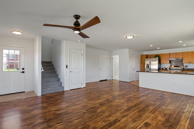 unfurnished living room with ceiling fan and dark hardwood / wood-style flooring