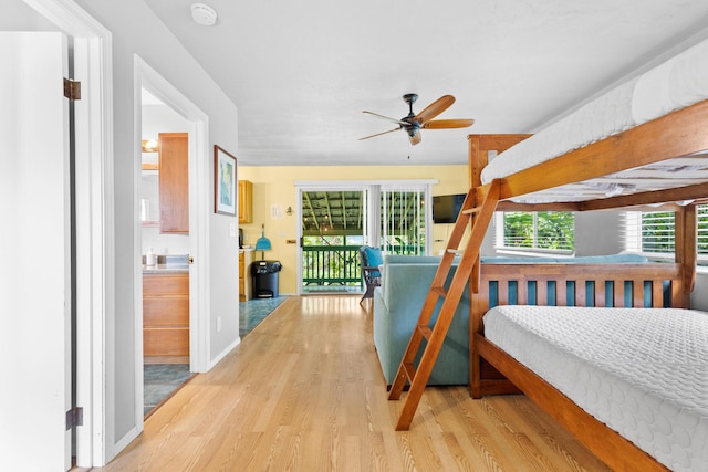 bedroom with ceiling fan, ensuite bath, access to exterior, and light wood-type flooring