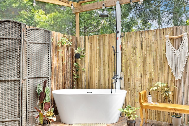 exterior space with hardwood / wood-style flooring, wooden walls, and a bathing tub