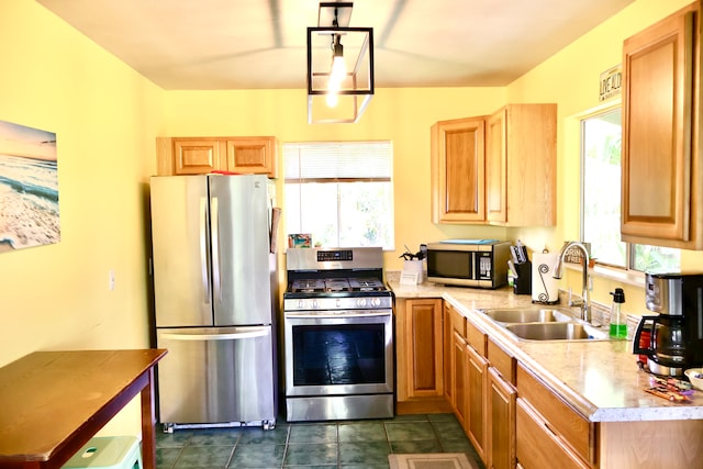 kitchen with stainless steel appliances, sink, and dark tile patterned floors