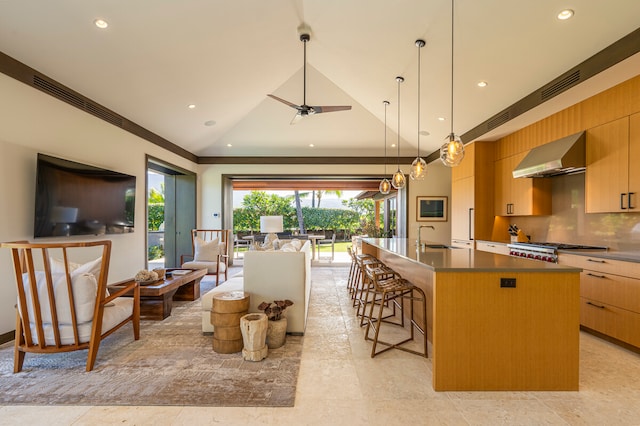 kitchen with a center island with sink, extractor fan, backsplash, vaulted ceiling, and ceiling fan