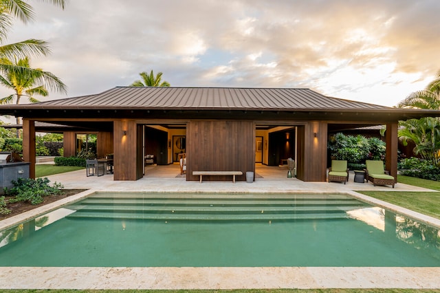 pool at dusk featuring a patio