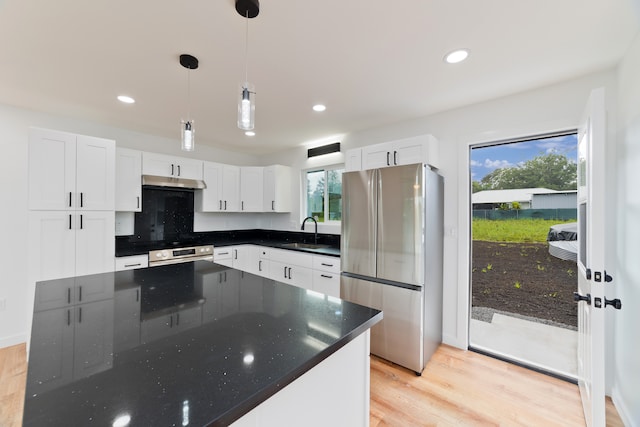 kitchen with appliances with stainless steel finishes, white cabinetry, and plenty of natural light