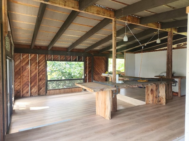 interior space with hardwood / wood-style flooring, vaulted ceiling with beams, and wood walls