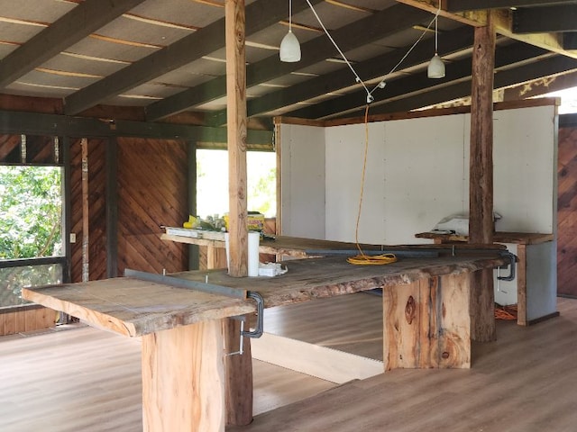 interior space with hardwood / wood-style floors, wooden walls, a wealth of natural light, and lofted ceiling